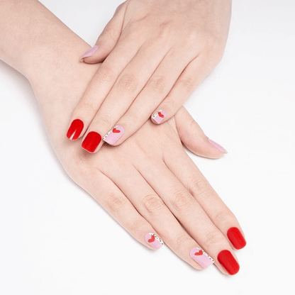 Red and pink romantic nail wraps with heart design on hands manicure