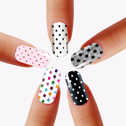 Colourful polka dot nail wraps on fingertips showing black, white, pink and multicoloured spotty designs