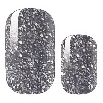 Black and grey terrazzo-effect nail wraps with fine silver fleck detailing.