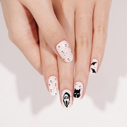 Gothic Halloween nail art with black and white ghost and cat designs