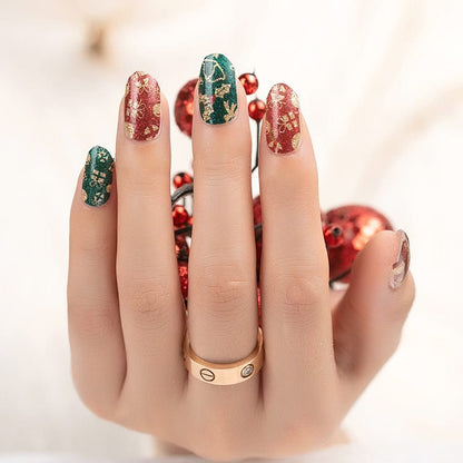 Christmas nail art manicure with red and green festive patterns on decorated hand