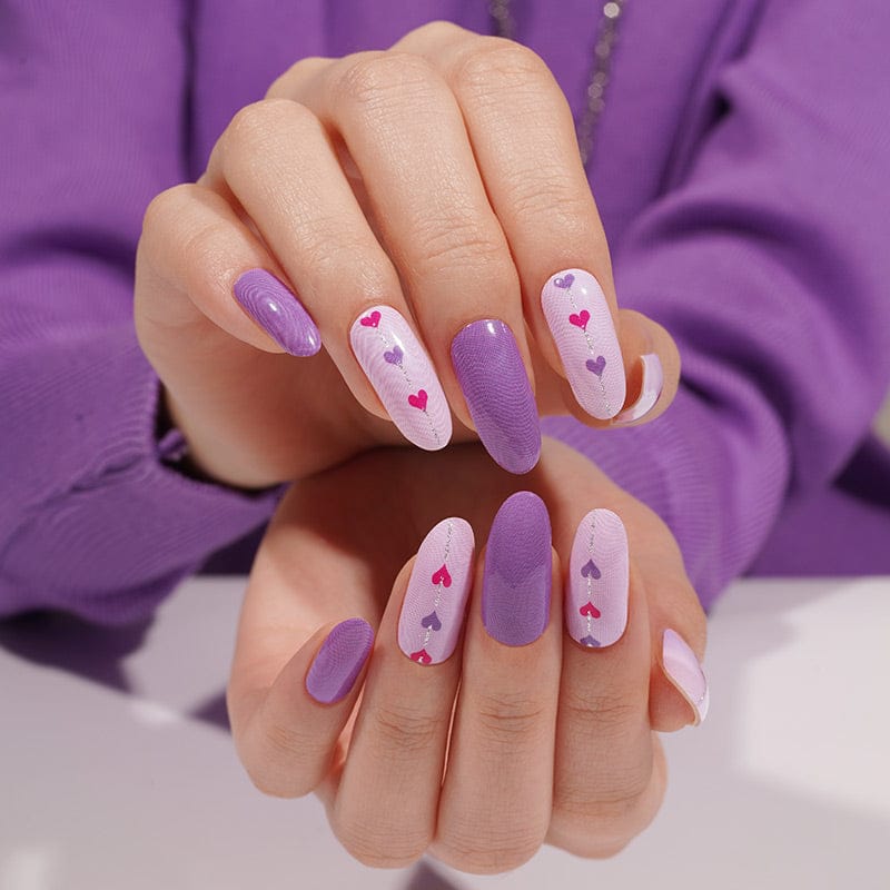 Purple glossy nail wraps with pale lilac accents and pink heart-trail design