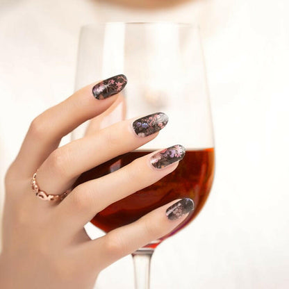 Black nail wraps with delicate pink and purple floral vine design, glossy finish