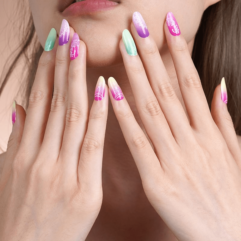 Both hands displaying tropical ombre nail wraps with white mandala nail art