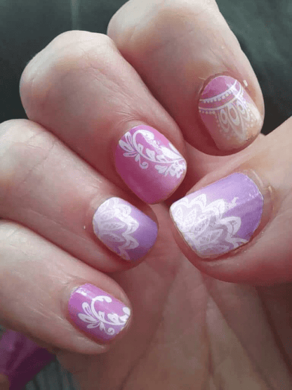 Tropical mandala nail art wraps in pink purple gradient with white paisley patterns on hand
