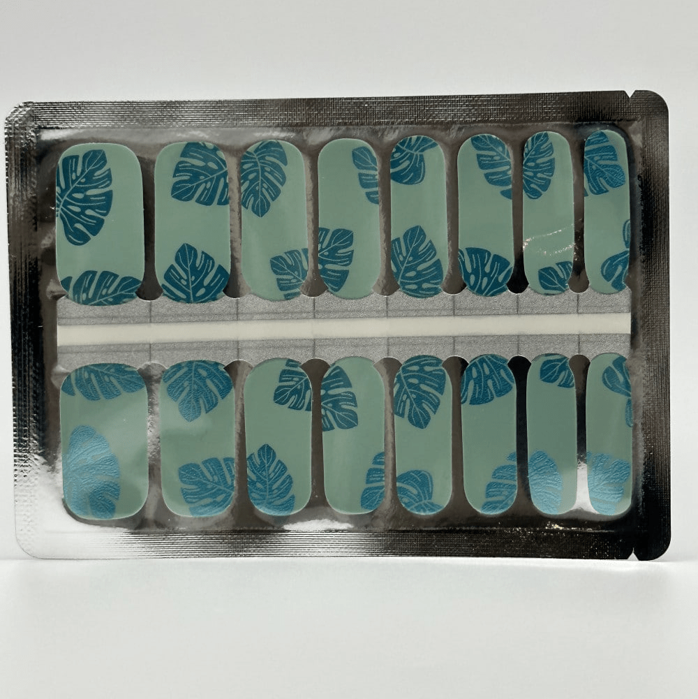 Turquoise nail wraps with blue metallic leaf pattern in packaging for at-home manicure