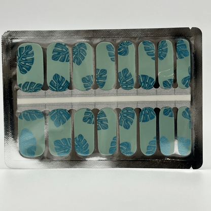 Turquoise nail wraps with blue metallic leaf pattern in packaging for at-home manicure