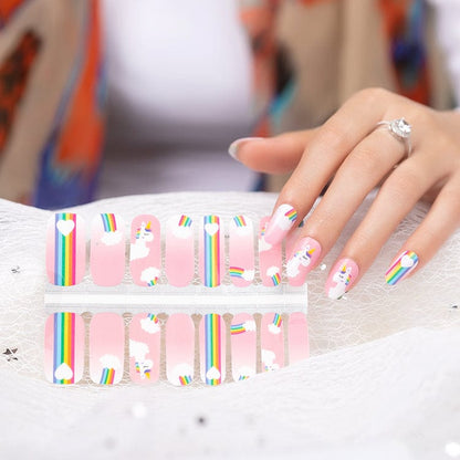 Unicorn rainbow nail wraps sheet with hand showing applied pink cartoon manicure design
