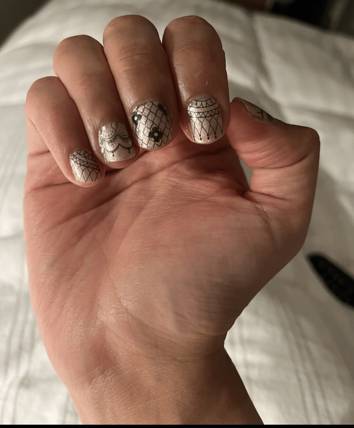 Delicate black lace nail art wraps on fingertips with vintage Victorian patterns