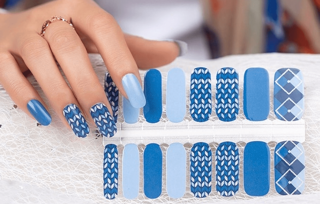 Blue nail wraps with knit-pattern, solid, and argyle designs in varied shades