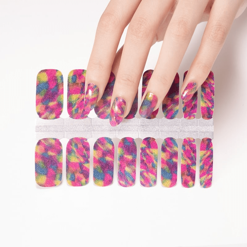 Hand applying colourful rainbow geometric nail wraps with matching sheet showing vibrant multicoloured patterns