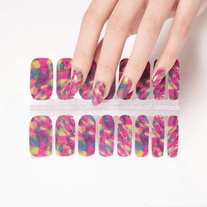 Hand applying colourful rainbow geometric nail wraps with matching sheet showing vibrant multicoloured patterns