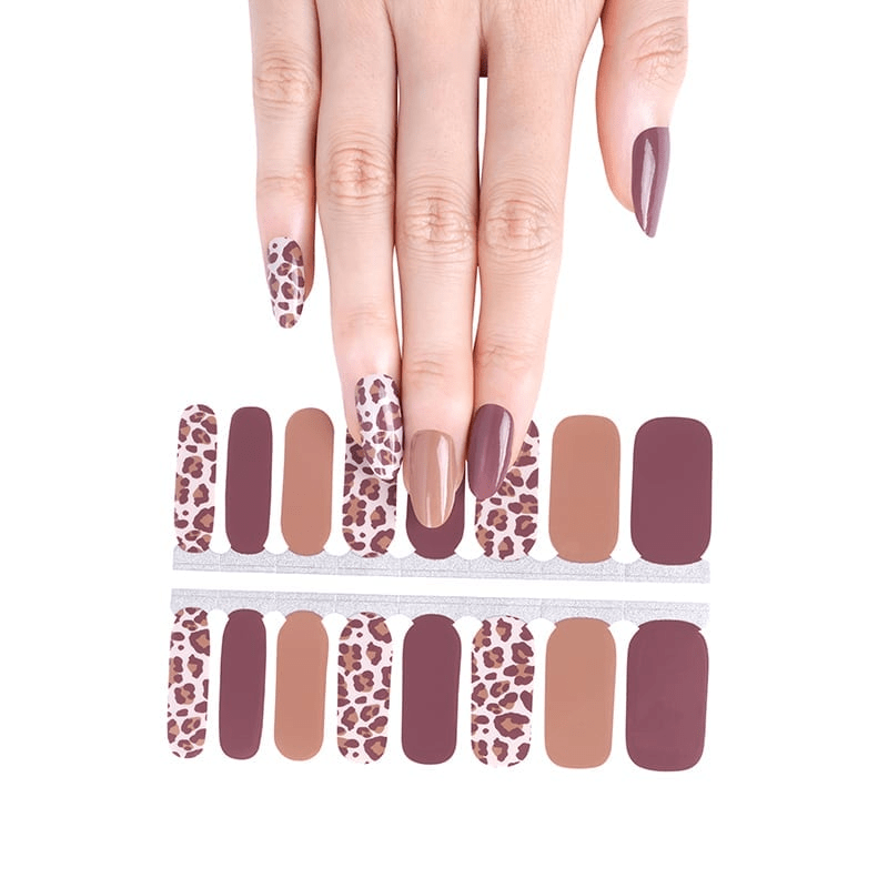 Leopard print nail wraps in burgundy taupe tones with hand displaying autumn animal print manicure