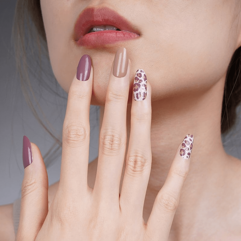 Elegant leopard print nail wraps on hand in burgundy taupe shades for sophisticated manicure