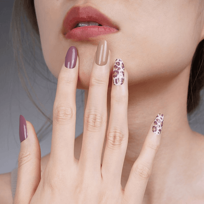 Elegant leopard print nail wraps on hand in burgundy taupe shades for sophisticated manicure