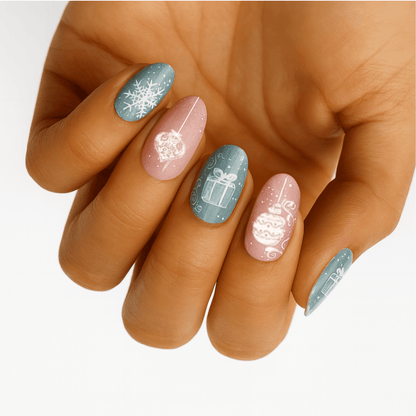 Christmas nail wraps on hand featuring sage blue and dusty rose with snowflakes and present designs