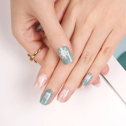 Close up of Christmas nail art featuring sage blue and dusty rose nail wraps with presents