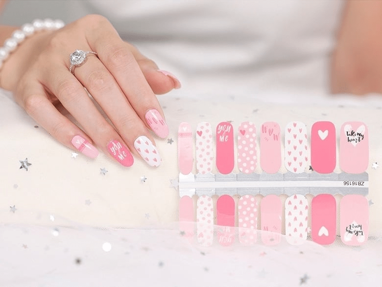 Pink heart nail wraps sheet showing Valentine's Day designs with polka dots and script
