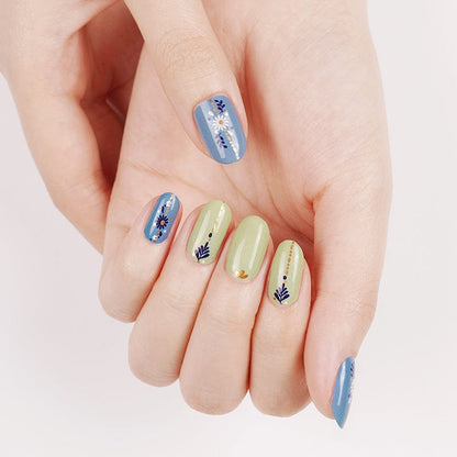 Holy Classics nail wraps in blue and sage green with daisy florals and gold accents
