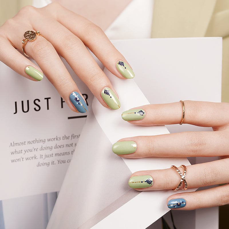 Boho nail art wraps in blue and green with botanical floral patterns on hands
