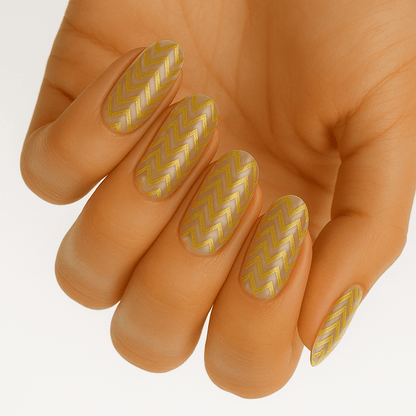 Gold chevron pattern nail wraps on hand with clear base and geometric design