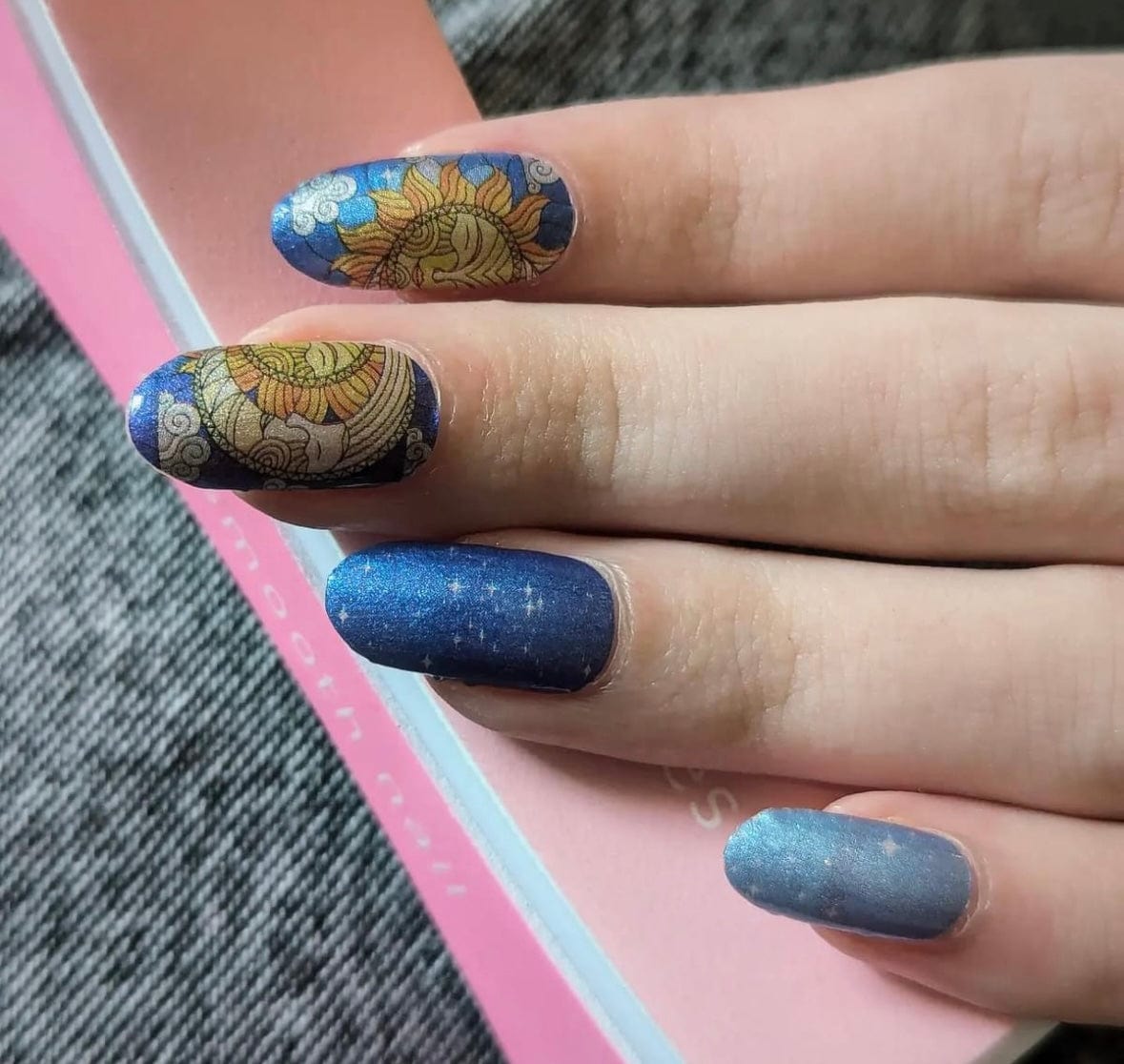 Navy nail wraps with gold mandala sun motif and shimmering starry blue accents