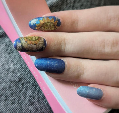 Navy nail wraps with gold mandala sun motif and shimmering starry blue accents