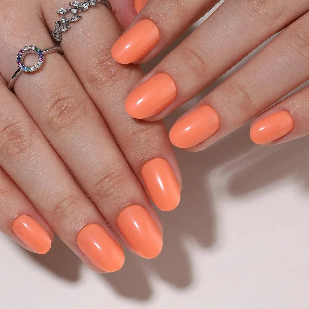 Coral orange gel press-on nails short oval manicure on both hands