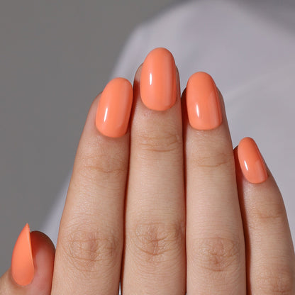 Citrus orange gel press-on nails short oval glossy finish on hand