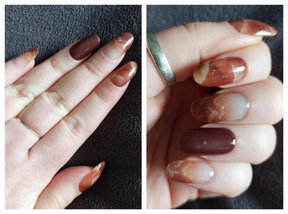 Brown amber cloud pattern gel nail wraps on hand showing glossy autumn manicure design