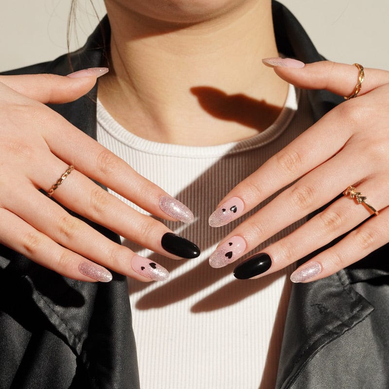 Black and pink glitter gel nail wraps with heart design on hands