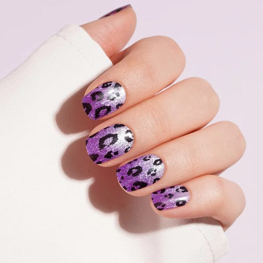Purple leopard print gel nail wraps on hand showing animal print nail art design