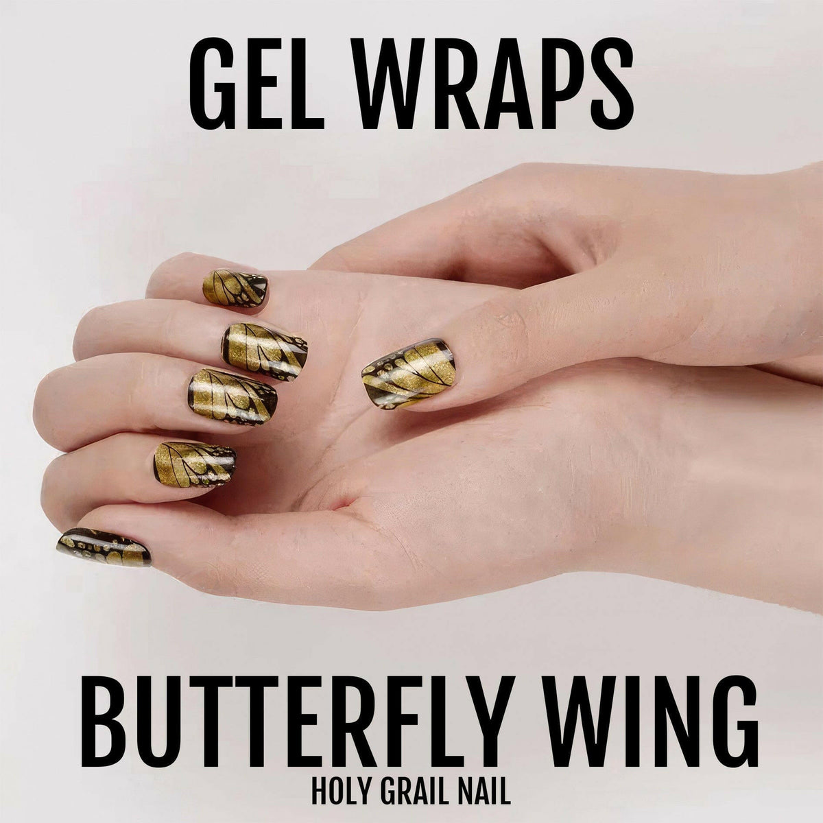 Gold butterfly wing pattern gel nail wraps on hand showing glossy metallic nail art design