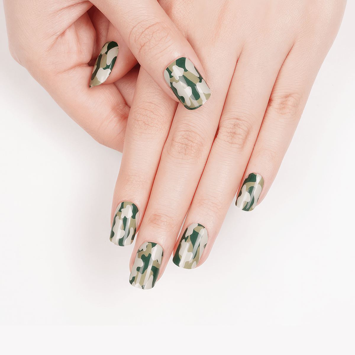 Green camouflage pattern gel nail wraps on hands showing military-style nail art design
