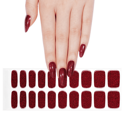 Hand wearing burgundy glitter gel nail wraps with matching nail wrap sheet