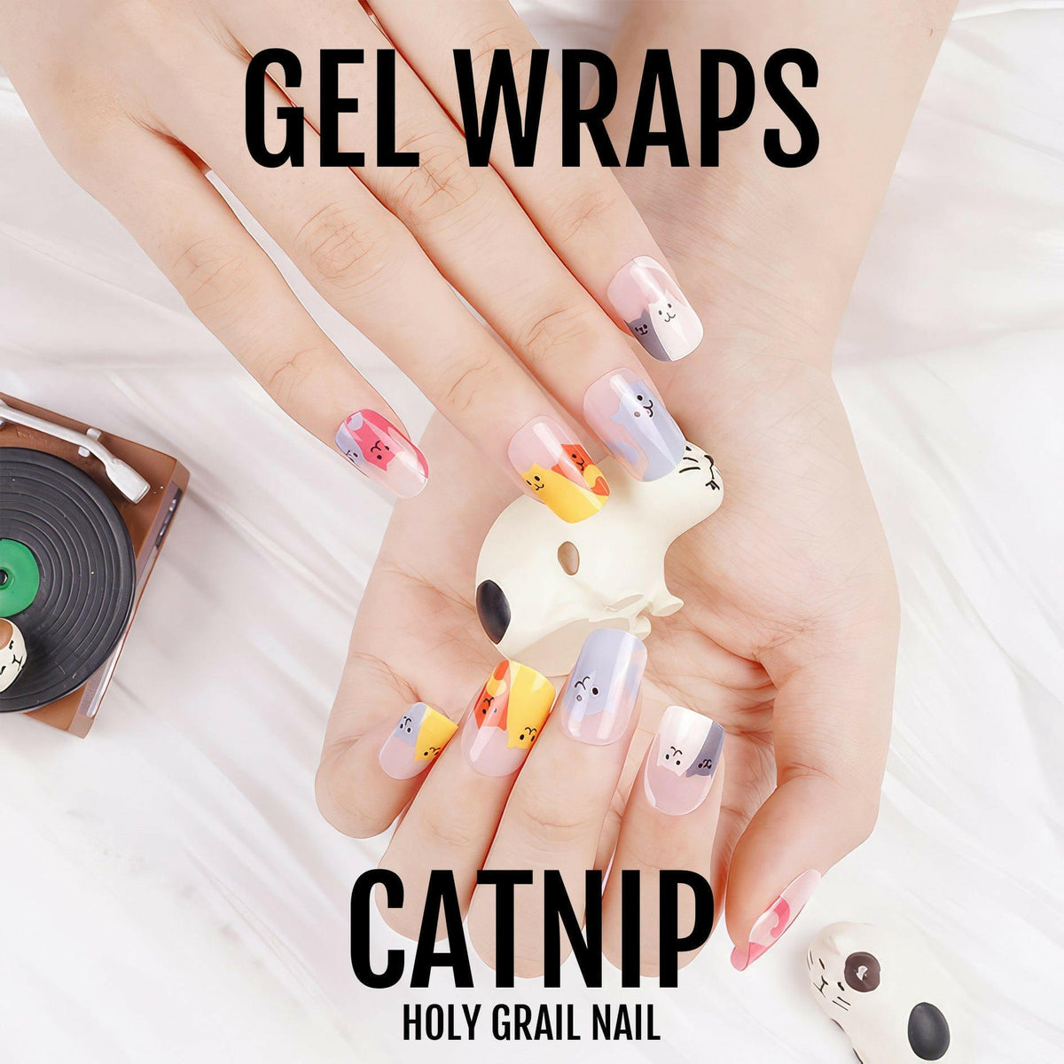 Hands displaying cute cat gel nail wraps featuring adorable kitten faces in multicoloured designs