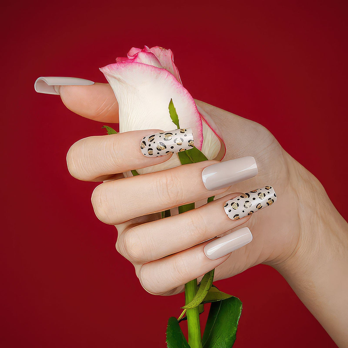 White gel nail wraps with cheetah print accent nails holding pink rose