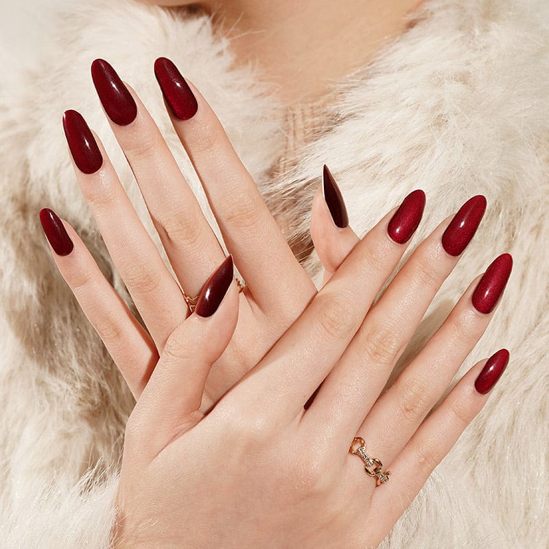 Dark red gel nail wraps on hands showing almond shape nail art design