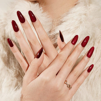 Dark red gel nail wraps on hands showing almond shape nail art design