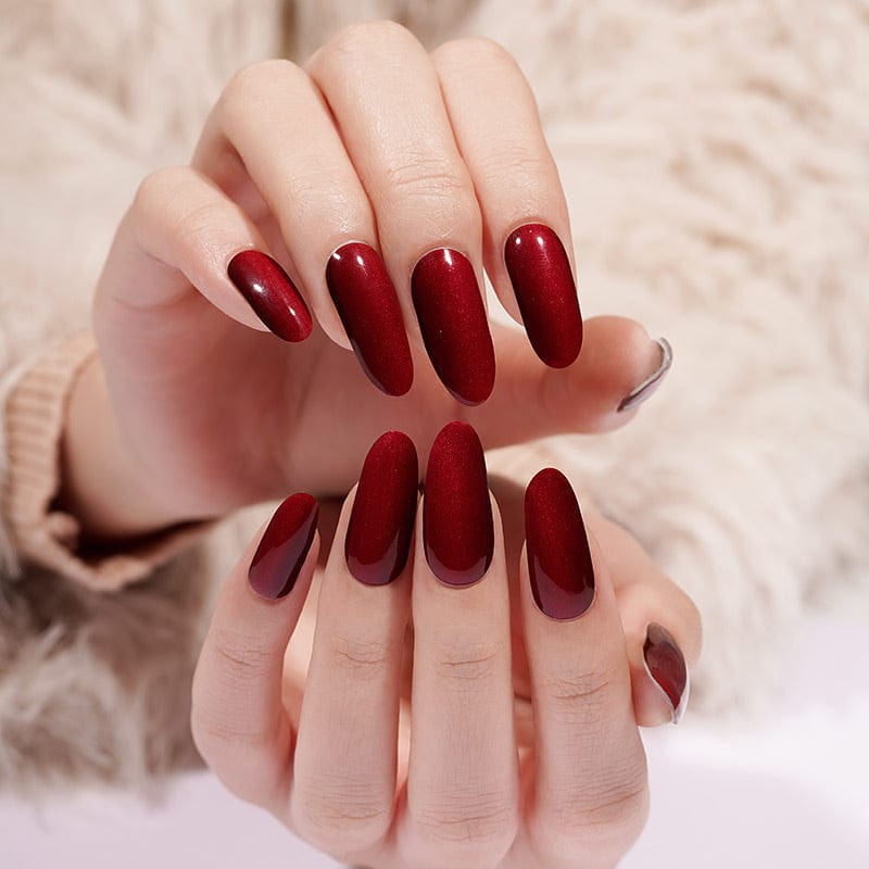 Deep red glossy gel nail wraps on hands showing long coffin manicure