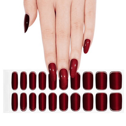 Hand displaying deep red glossy gel nail wraps with individual nail wrap sheet