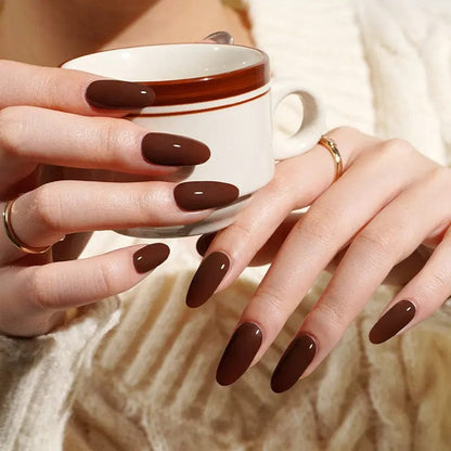 Hands holding white mug showing chocolate truffle brown gel nail wraps with glossy finish