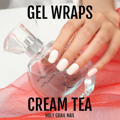 Hand with cream white gel nail wraps holding glass perfume bottle lifestyle shot