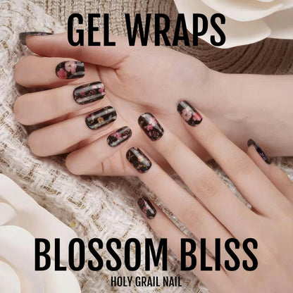 Black gel nail wraps with pink floral design on hands for at-home manicure