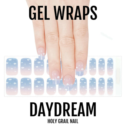 Blue cloud pattern gel nail wraps on hand showing dreamy sky design