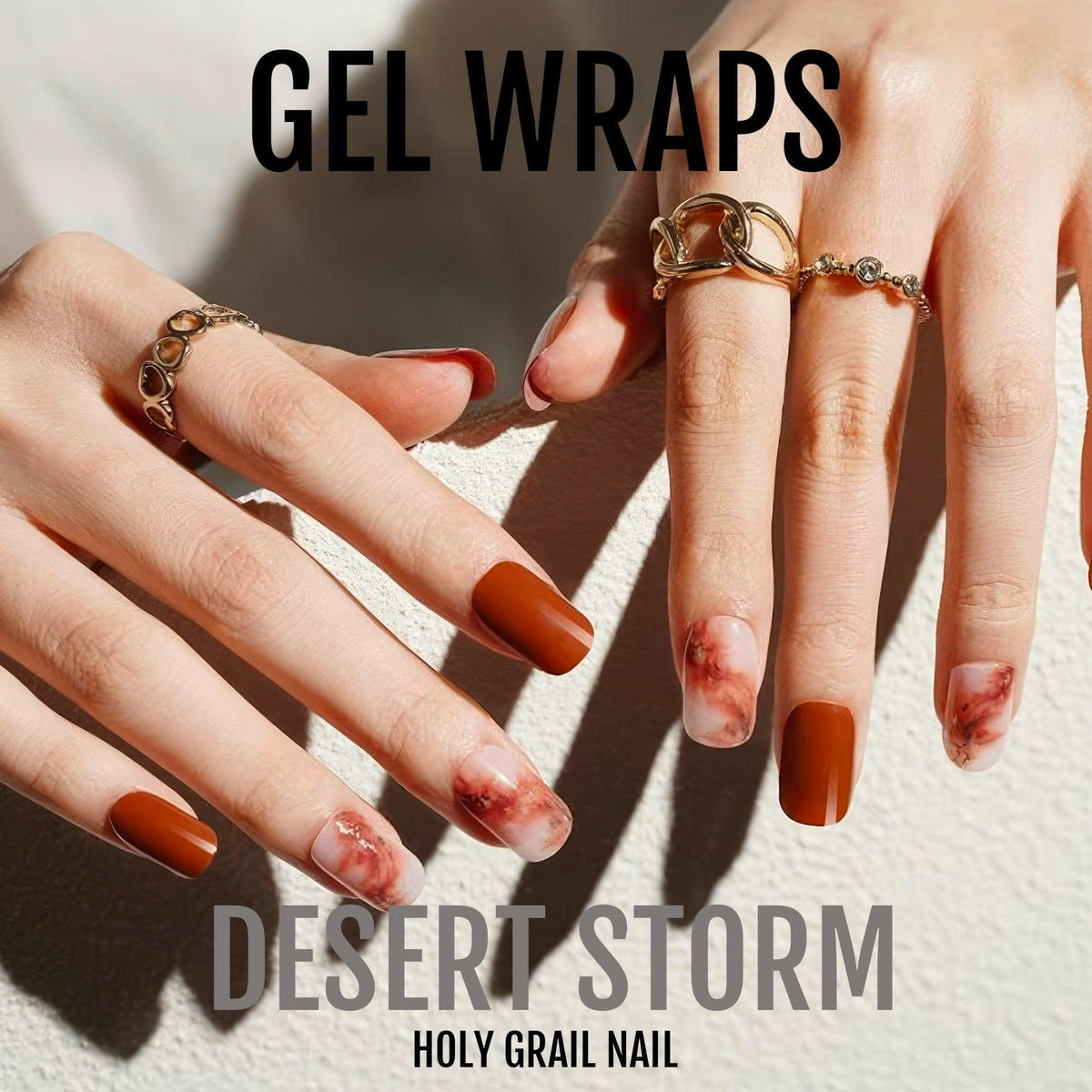 Orange and red marble gel nail wraps on hands with gold rings