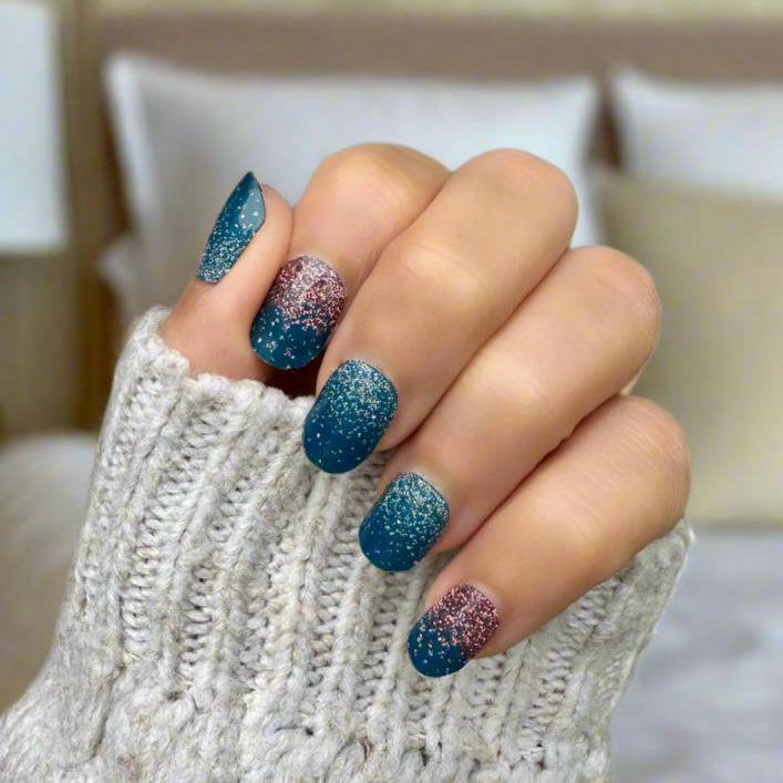 Hand wearing navy and rose gold glitter gel nail wraps in coffin shape design