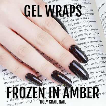 Black amber glitter gel nail wraps applied on hand showing glossy finish