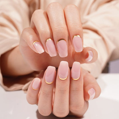 Dusty pink gel nail wraps with gold shimmer on hands at-home manicure