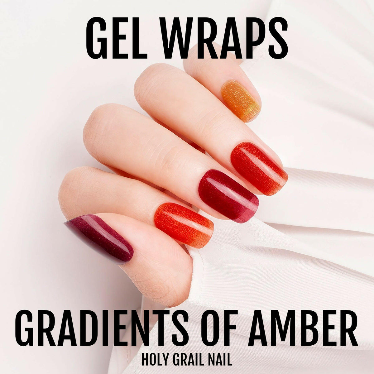 Hand wearing glossy gel nail wraps in amber gradient from burgundy to orange ombre design